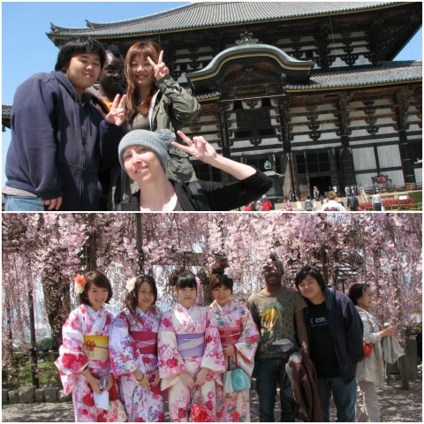 Justin posing with friends in front of a temple and cherry blossom trees.