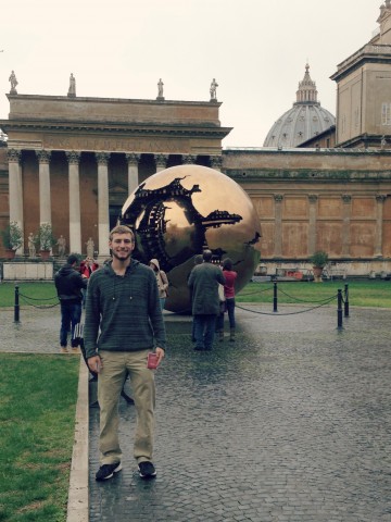 David standing in front of a spherical art sculpture.